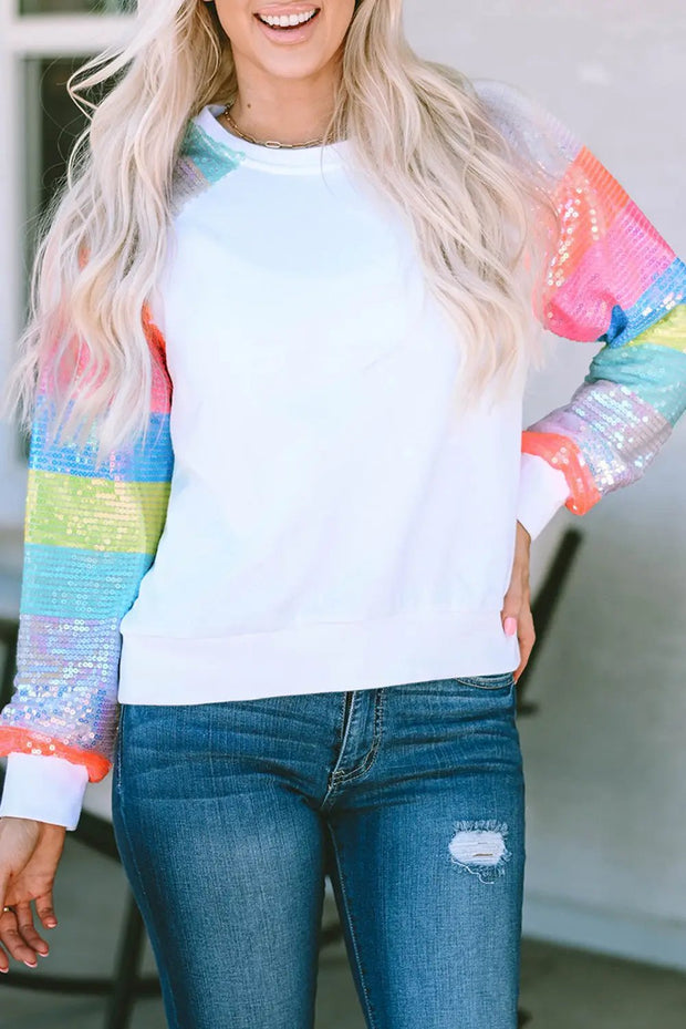 a woman with blonde hair wearing a white sweatshirt and ripped jeans