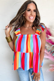 a woman posing for a picture wearing a colorful top