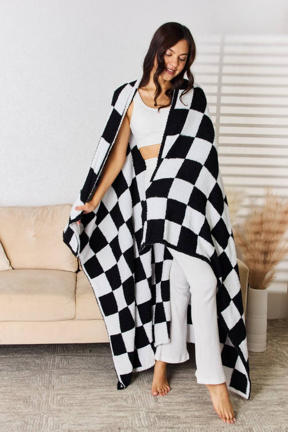 a woman wearing a black and white checkered blanket