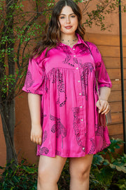 a woman in a pink shirt dress posing for a picture