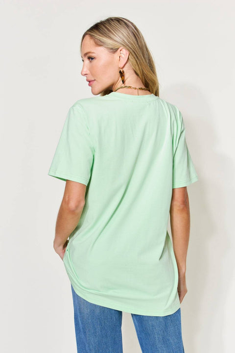 a woman wearing a mint green shirt and jeans