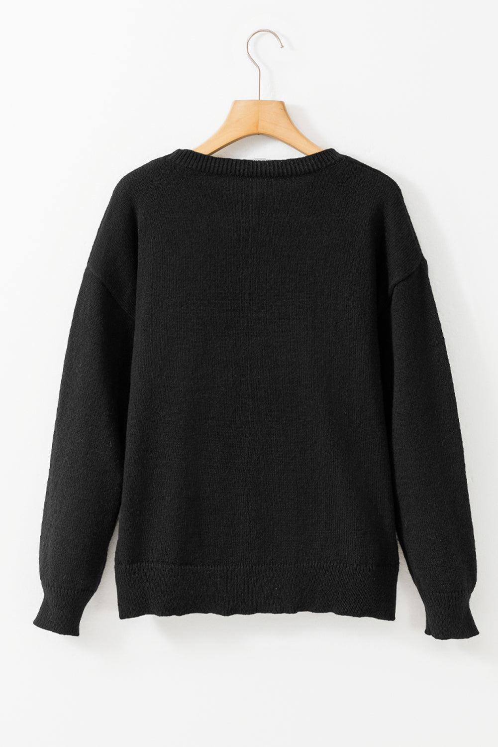 a black sweater hanging on a hanger