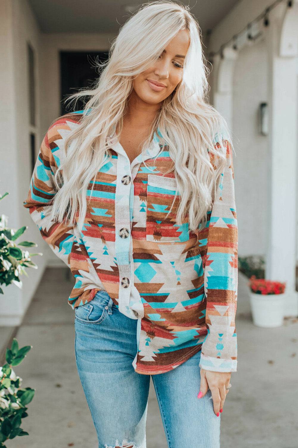 a woman wearing a colorful shirt and ripped jeans