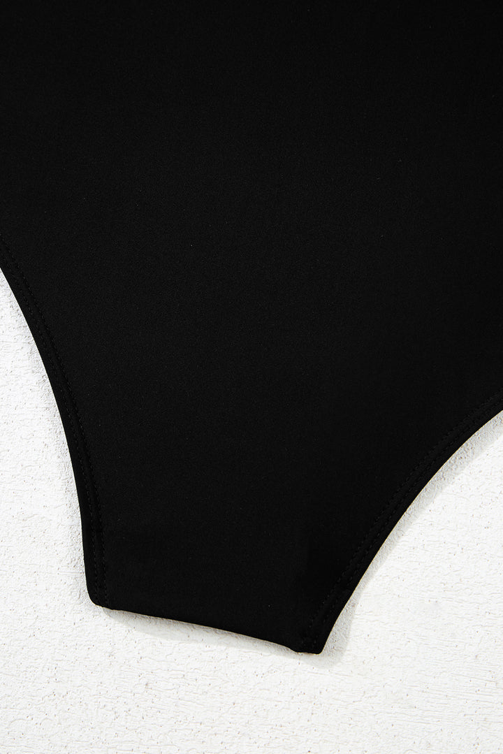 Detailed view of solid black bottom of 2-tone Crossed Cutout Backless Monokini, highlighting smooth fabric and clean stitching.