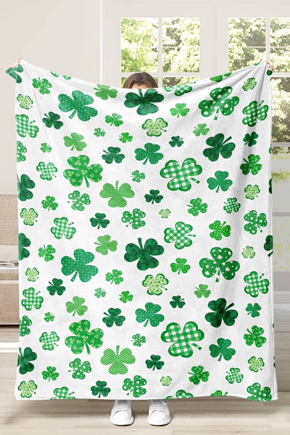 a person holding a blanket with shamrocks on it