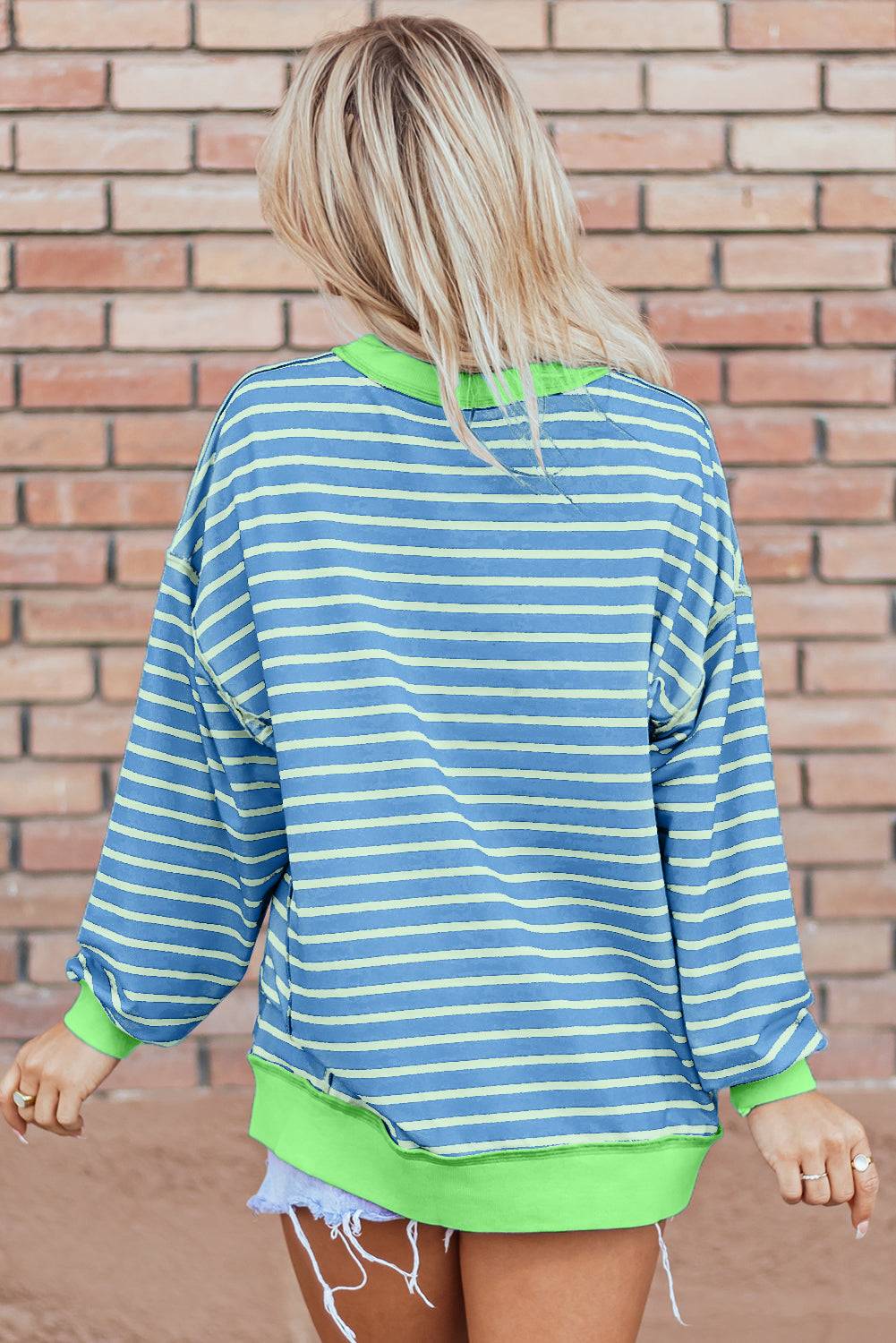 a woman wearing a blue and green striped top