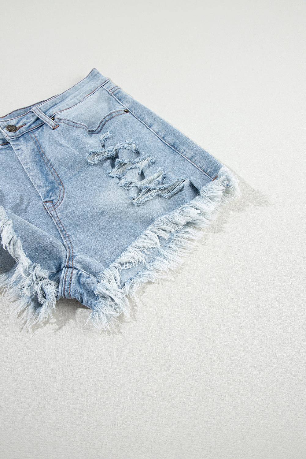 a pair of destroyed denim shorts on a white surface