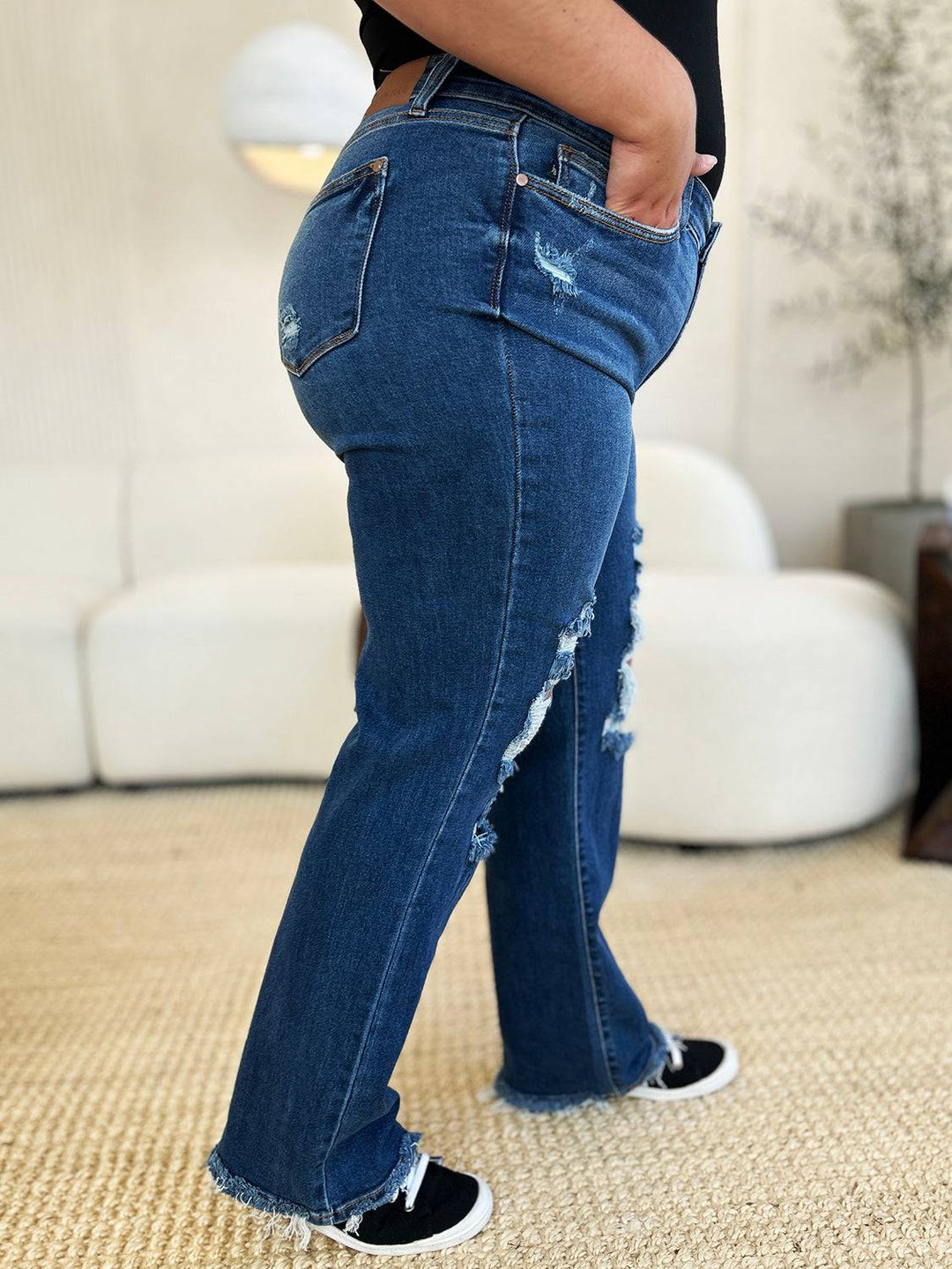 a woman in black shirt and jeans standing in a room