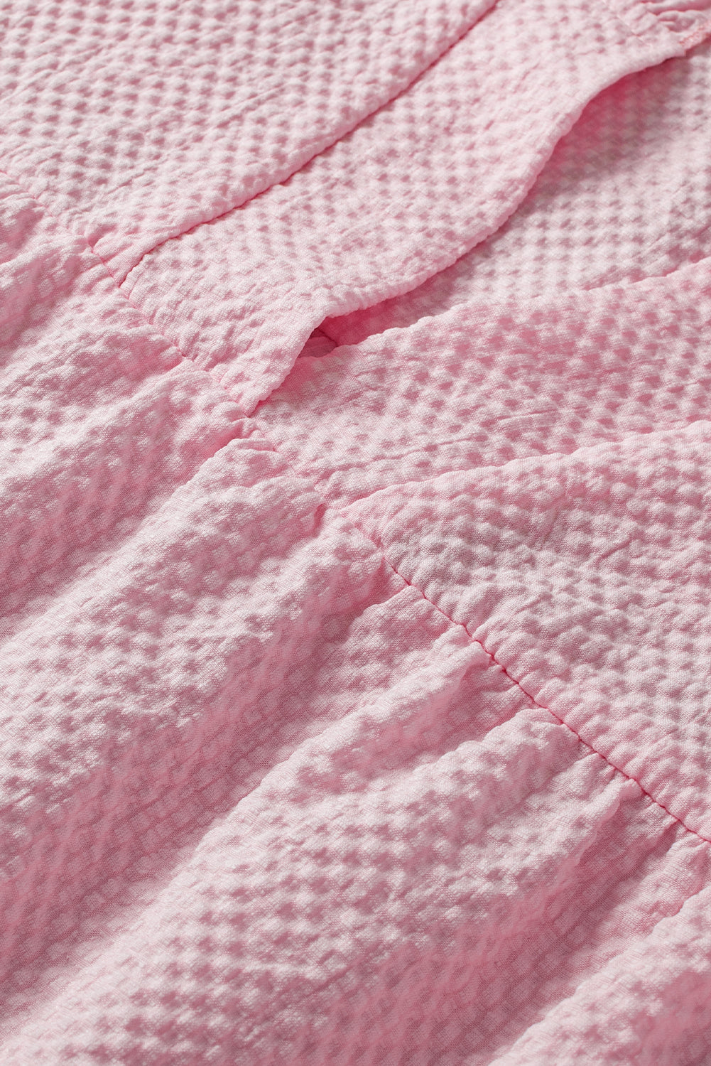 a close up of a pink blanket on a bed