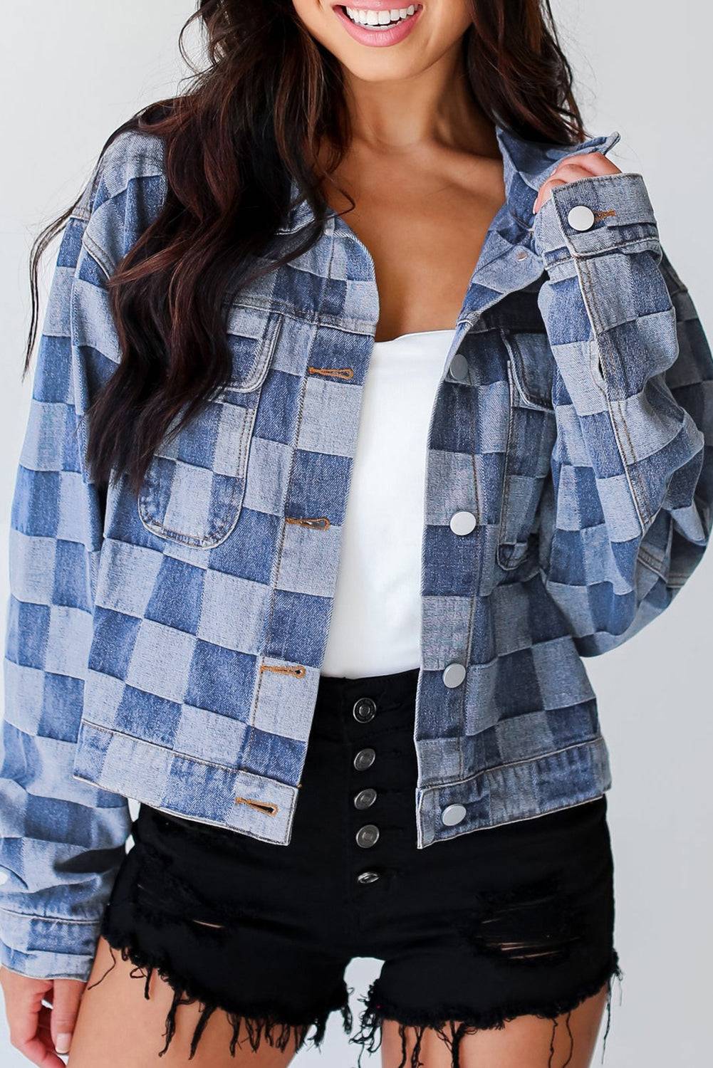 Light blue checkered patchwork button up denim jacket with front pockets, styled casually with black distressed shorts. Shop at Faith & Co. Boutique.
