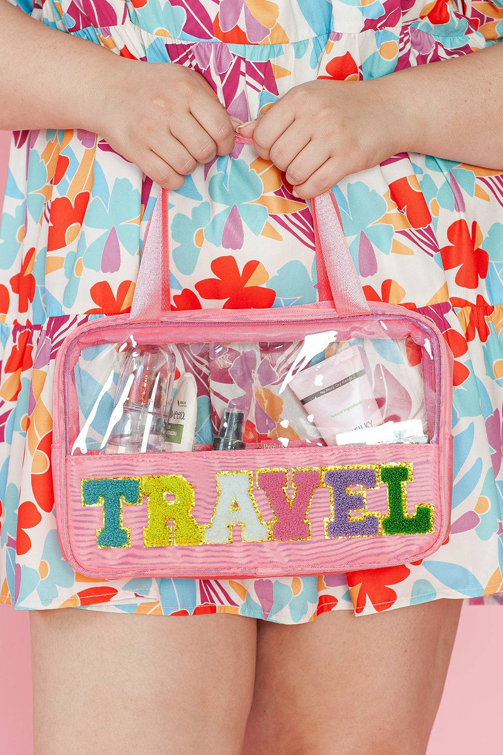a woman holding a pink travel bag filled with personal items