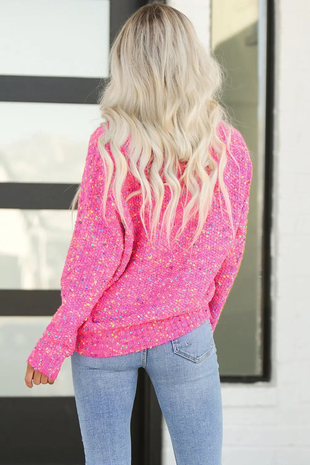 a woman wearing a pink sweater and jeans