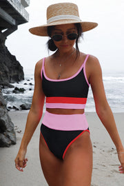 a woman in a bikini and hat walking on the beach