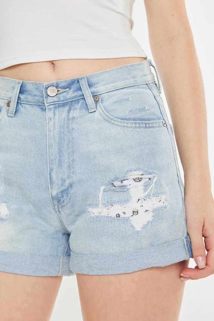 a woman is wearing a pair of shorts with holes
