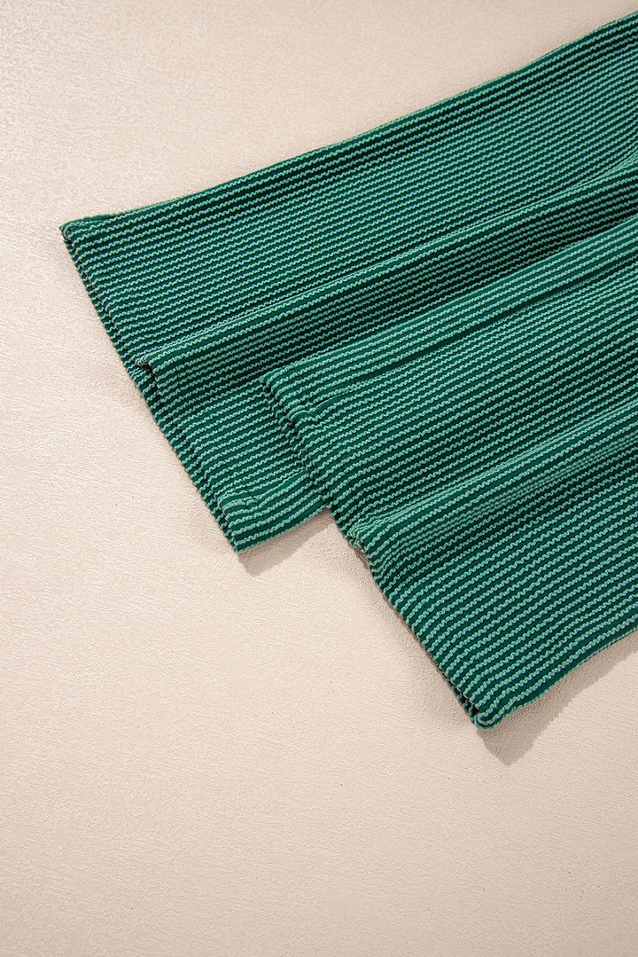 Pant hem detail of green Evergreen JOLLY Corded Pants. Wide-leg cut with ribbed fabric from Faith & Co. Boutique.