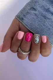 a woman's hand with a pink and silver manicure