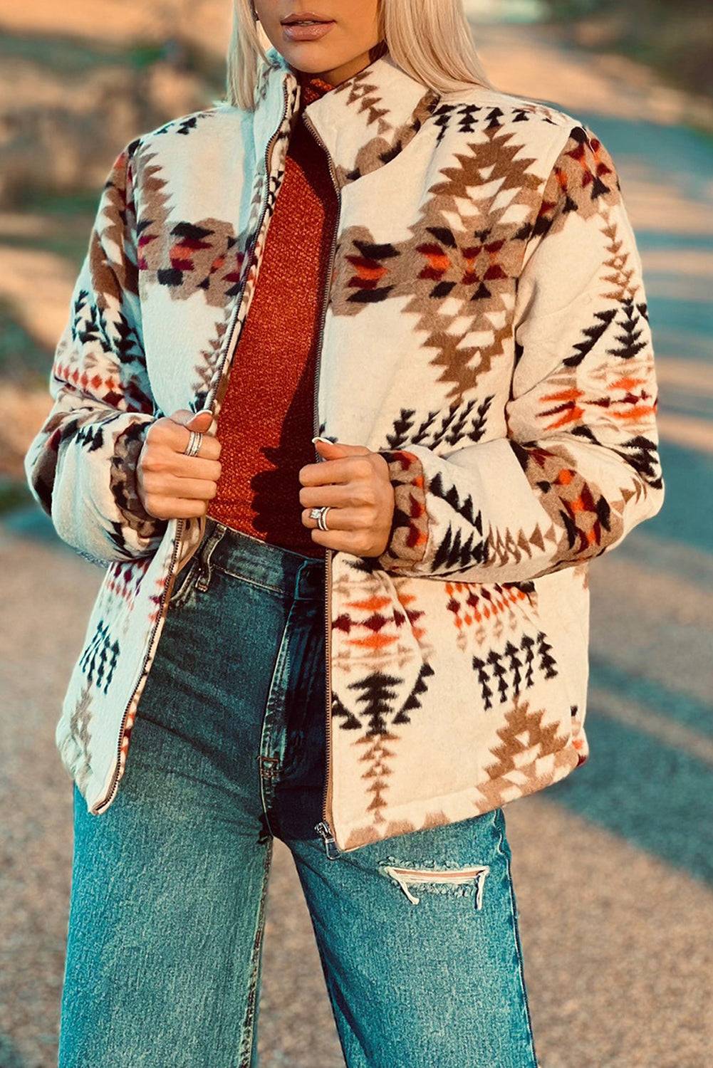 a woman with blonde hair wearing a jacket and jeans