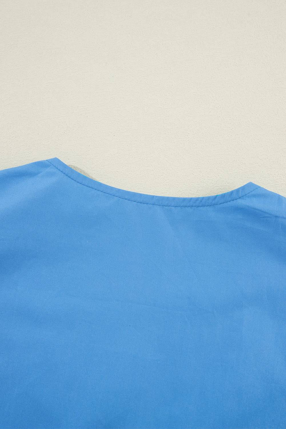 a blue shirt laying on top of a white wall