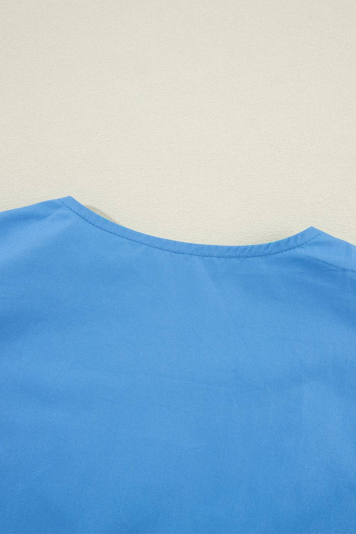 a blue shirt laying on top of a white wall