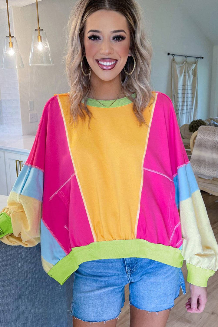 a woman standing in a room wearing a colorful top