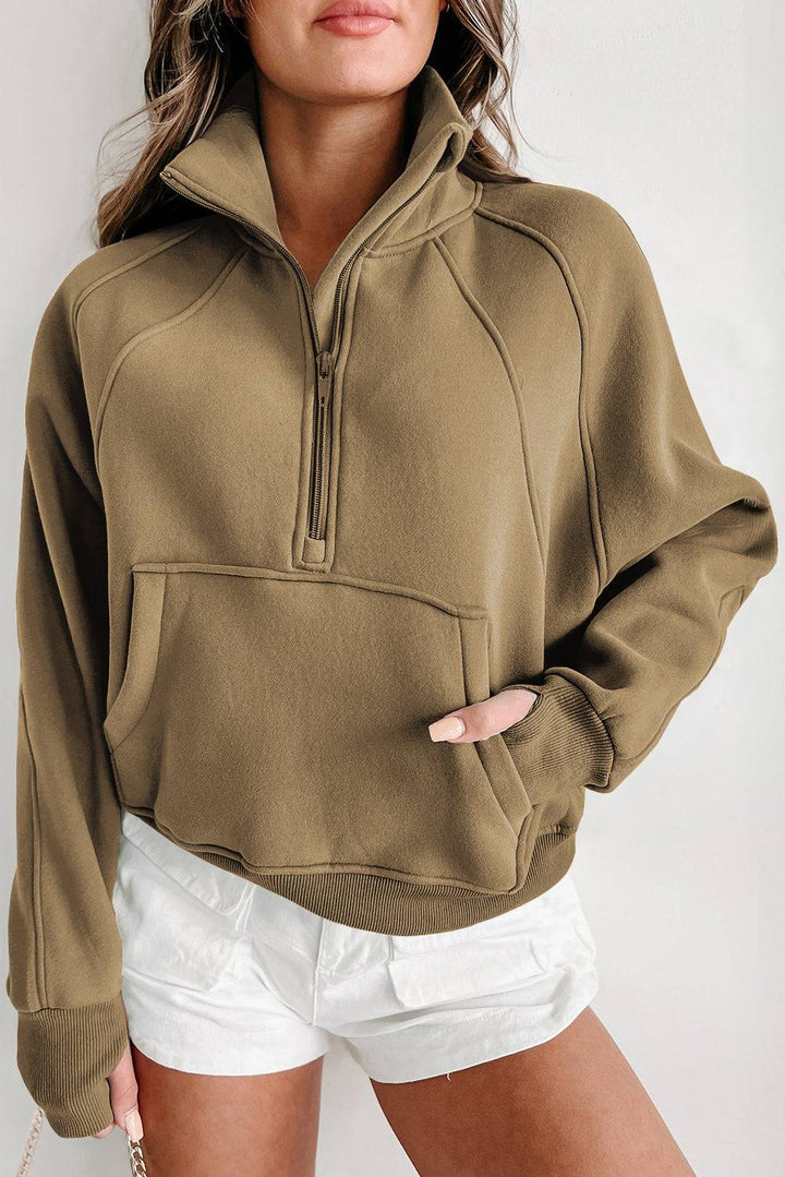 a woman wearing a brown sweatshirt and white shorts