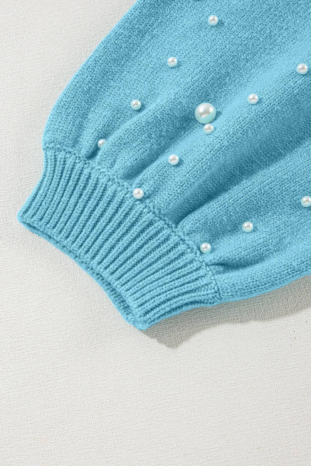 a blue sweater with white pearls on it