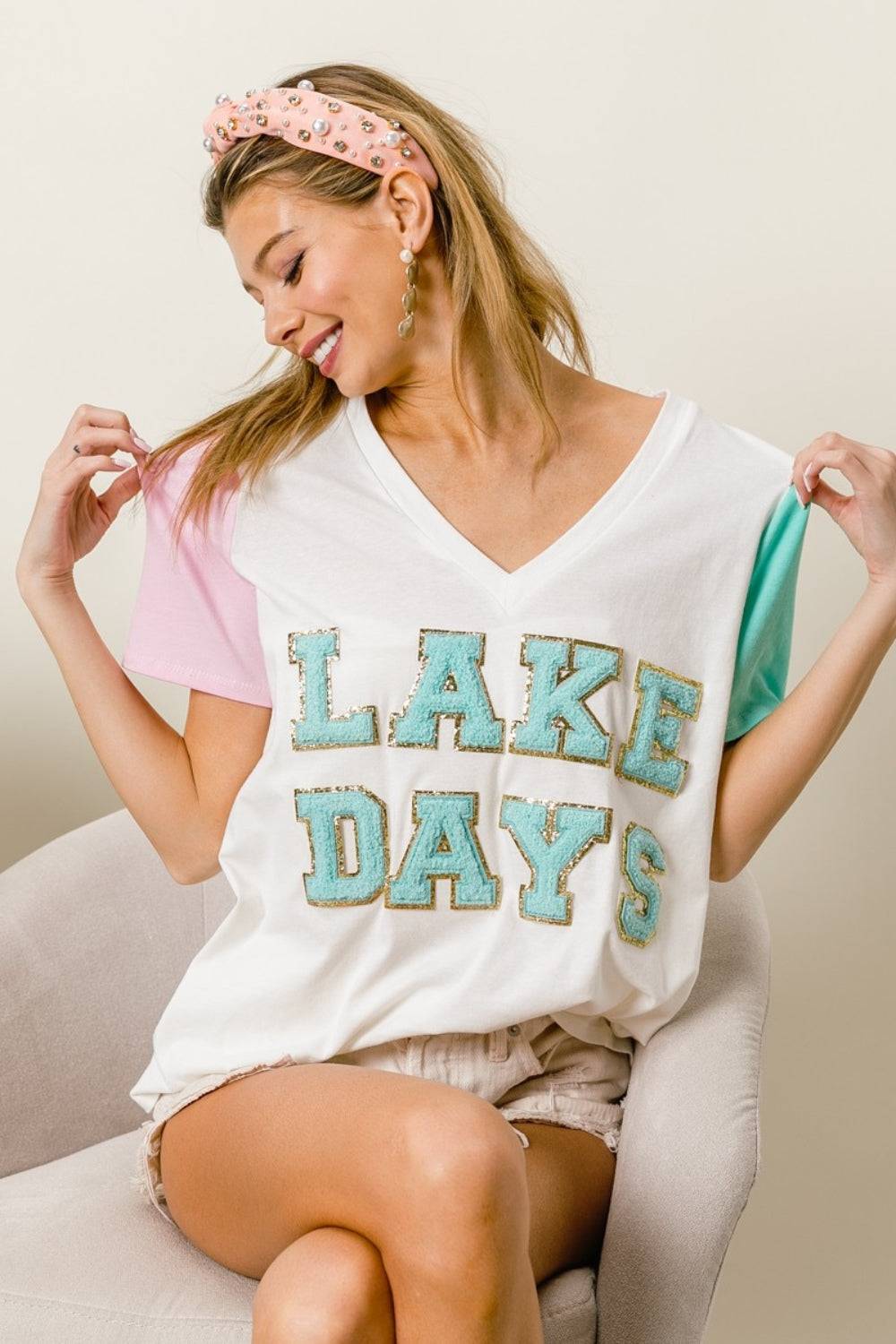 a woman sitting on a chair wearing a shirt that says lake days