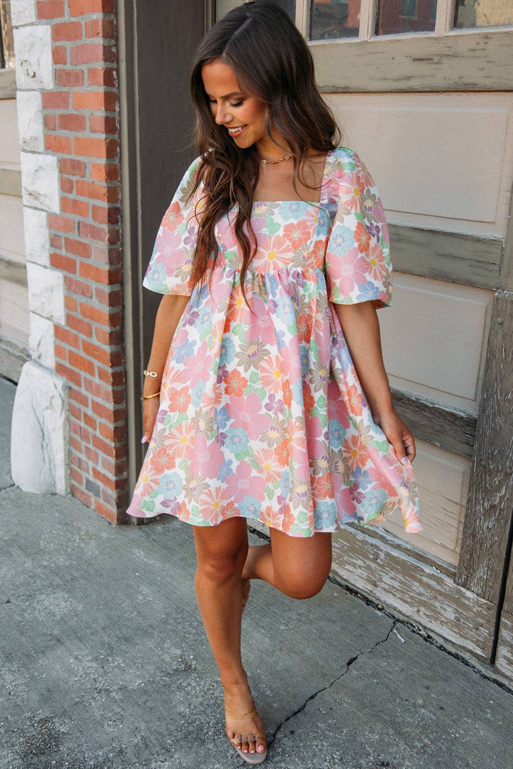 a woman in a floral dress is standing on the sidewalk