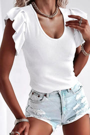 a woman wearing a white top and denim shorts