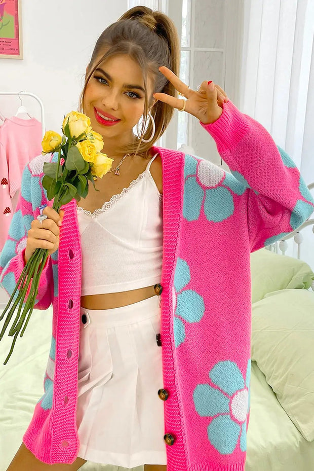 a woman in a pink cardigan holding a bouquet of flowers