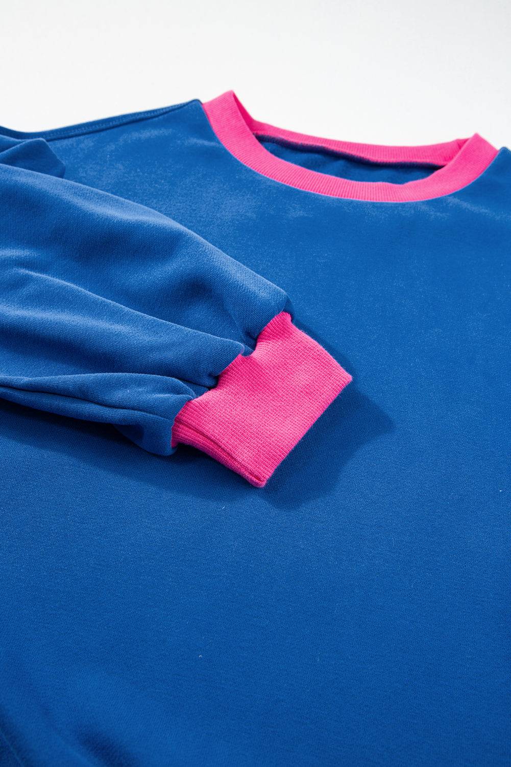 a blue shirt with a pink patch on it