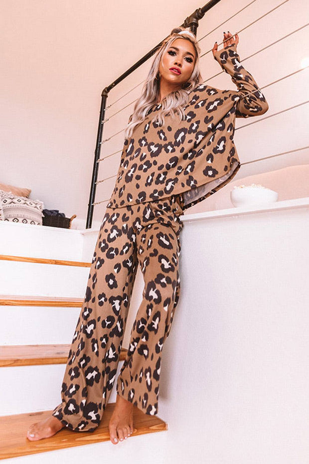 a woman in a leopard print jumpsuit standing on a staircase