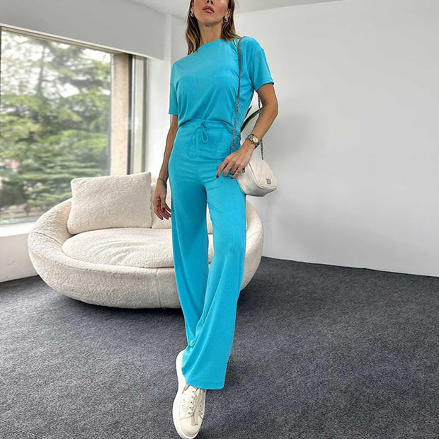 a woman in a blue jumpsuit standing in a living room