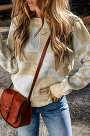 a woman in a sweater and jeans holding a brown purse