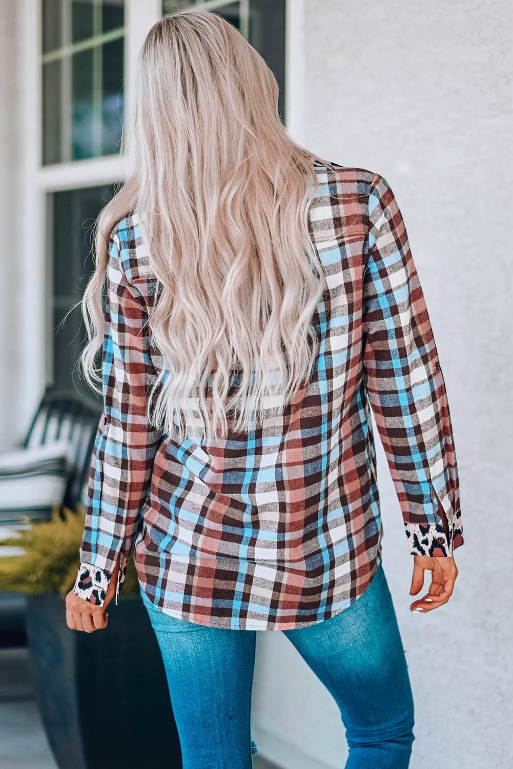 a woman with long blonde hair wearing a plaid shirt