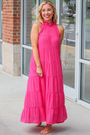 a woman standing in front of a building wearing a pink dress