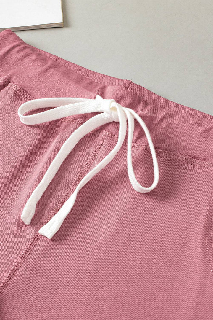 a close up of a pink shorts with a white tie