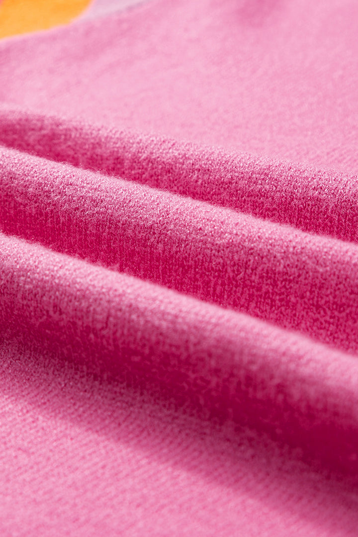 a close up of a pink fabric with a yellow circle on it