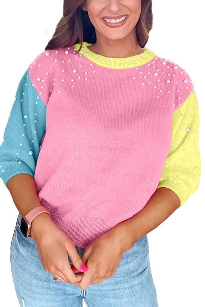 a woman wearing a pink and blue sweater