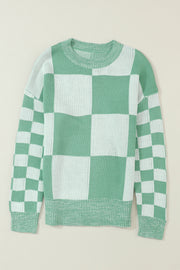 a green and white checkered sweater hanging on a wall