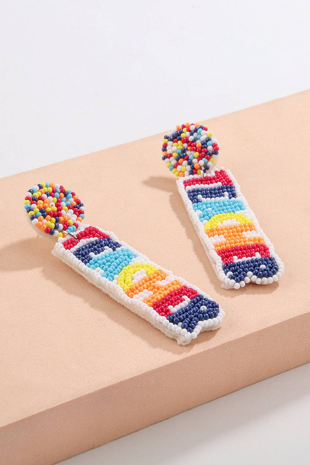 a pair of colorful beaded earrings sitting on top of a table