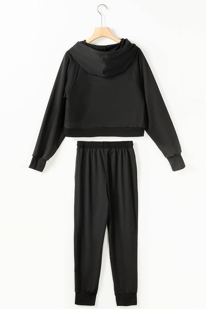 a black hoodie and sweatpants set hanging on a hanger