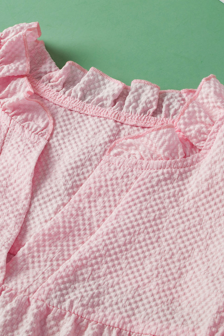 a close up of a pink shirt on a green surface