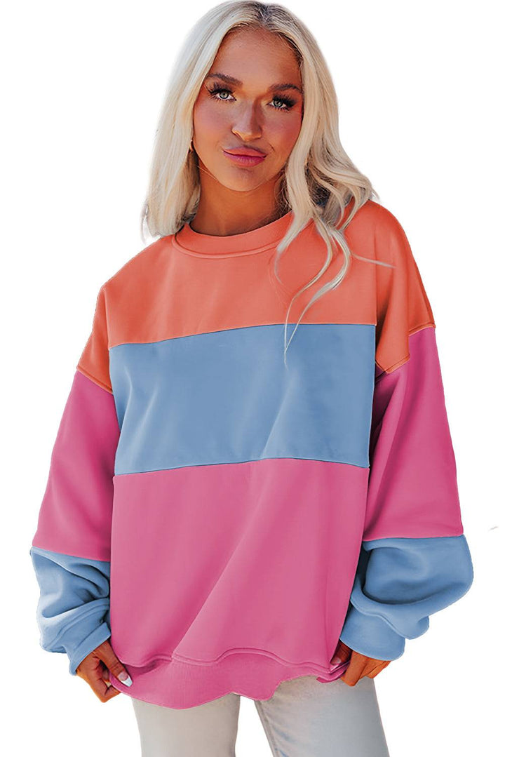 a woman wearing a pink and blue sweatshirt