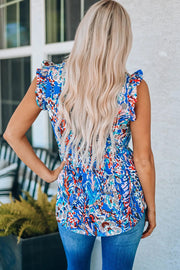 a woman with blonde hair wearing a blue floral top