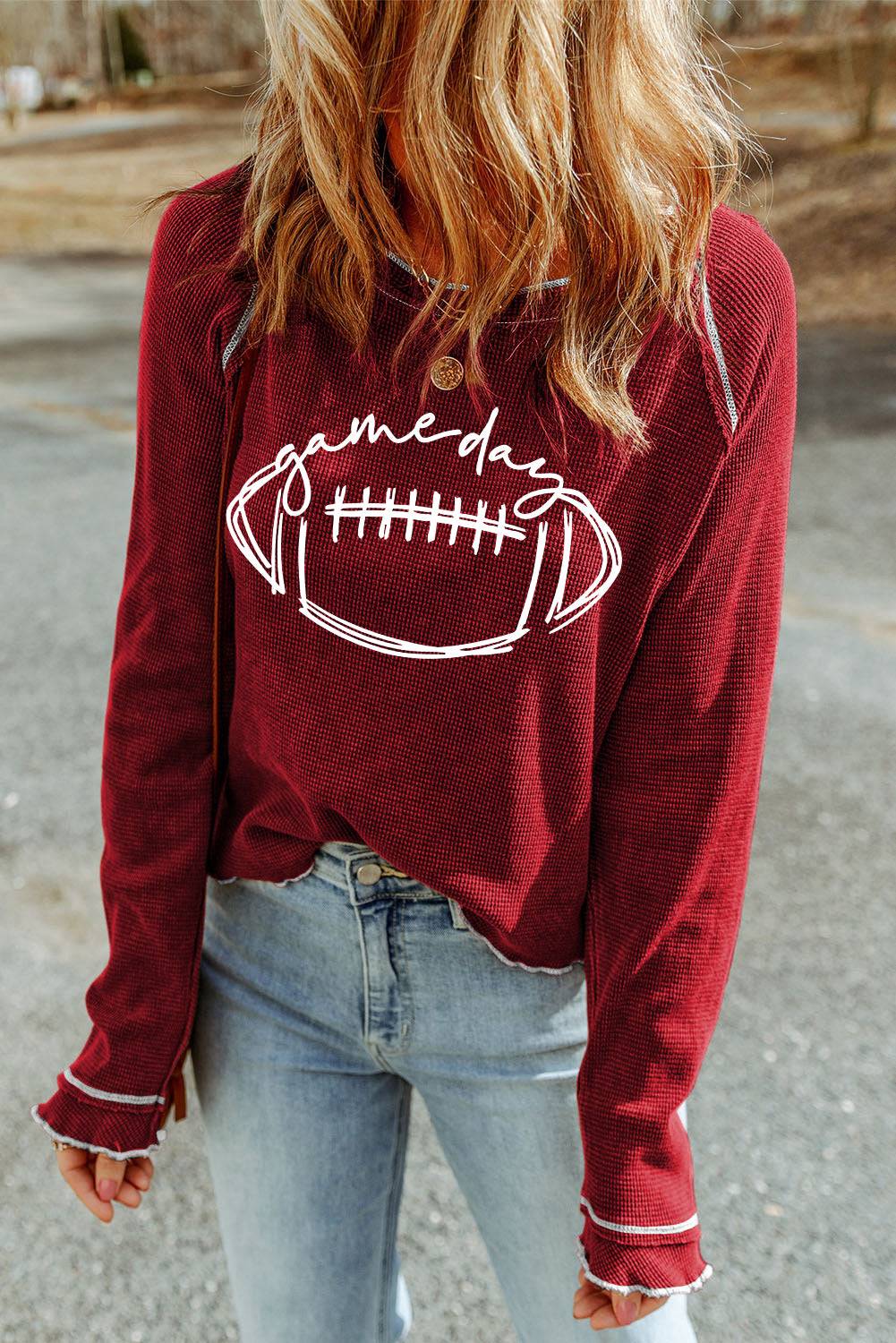 a woman wearing a sweatshirt with a football on it