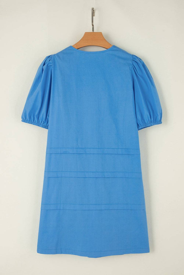 a blue dress hanging on a wooden hanger