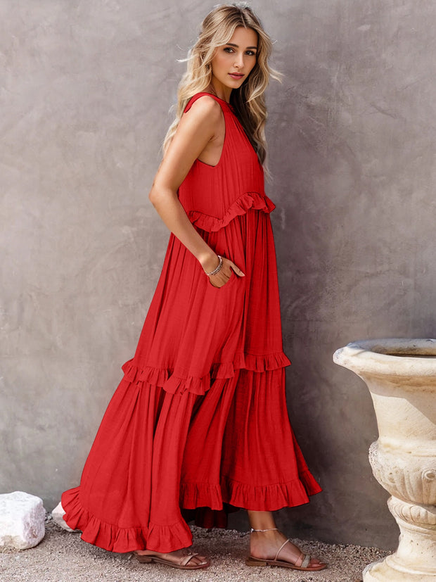 a woman in a red dress leaning against a wall