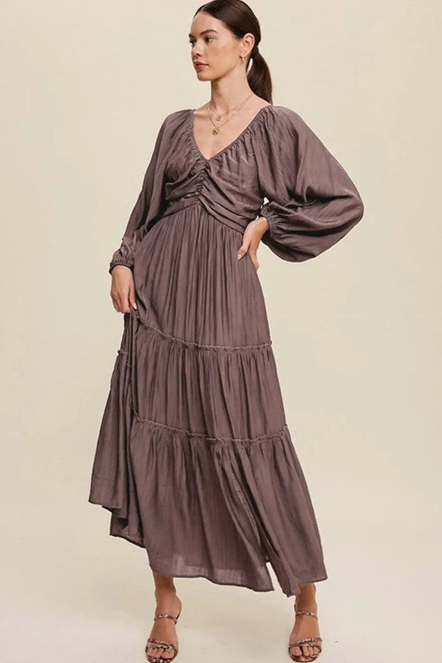 a woman is wearing a long dress and sandals