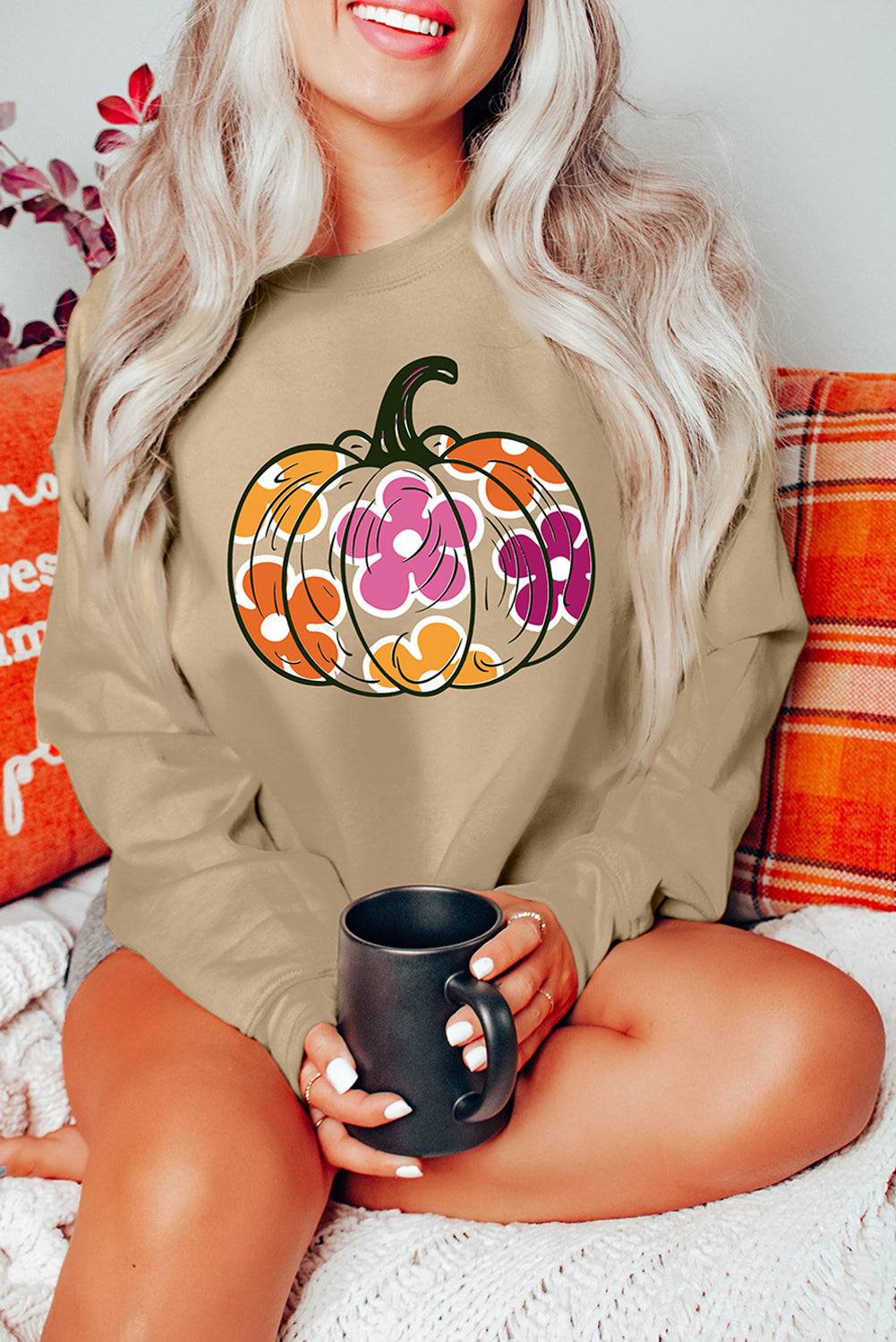 a woman sitting on a bed holding a coffee mug